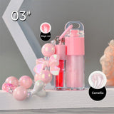 Two-piece Set Of Color-changing Lip Oils And A Bow-shaped Pearl Bracelet Charm.