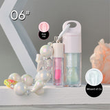 Two-piece Set Of Color-changing Lip Oils And A Bow-shaped Pearl Bracelet Charm.